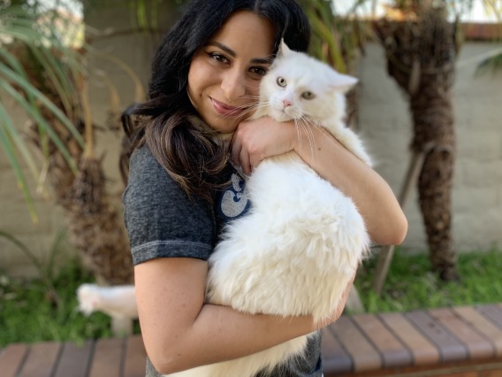 Veterinary student Cristina Guijon holds a white cat.