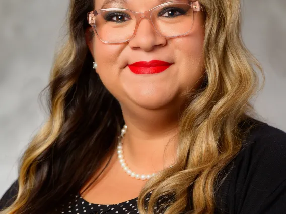 Headshot, woman with long hair and dark clothing.