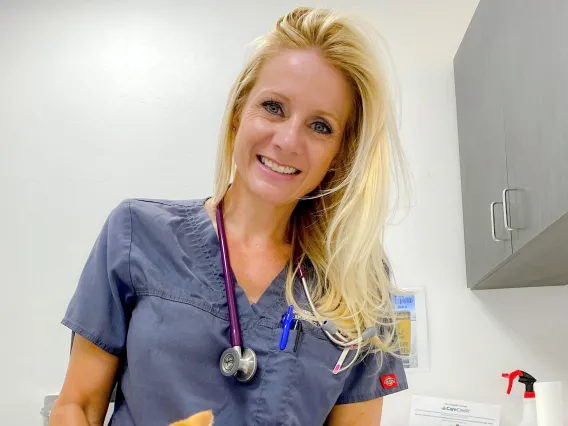 Dr. Lindsay Juhl holds a small orange kitten and smiles.