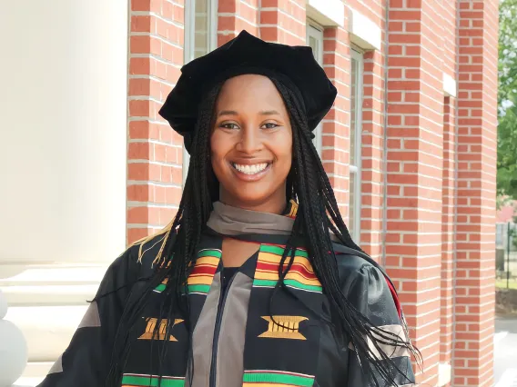 Jasmine Worthy wears graduation regalia and a graduation stole that reads "Class of 2023" and "Black Girl Magic."