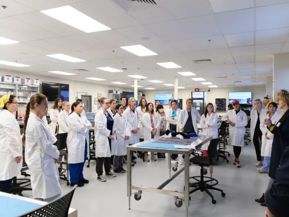 Students listening to a faculty member while in a lab. 