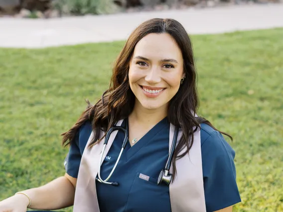 Alyssa Rankin smiling and sitting on the grass.