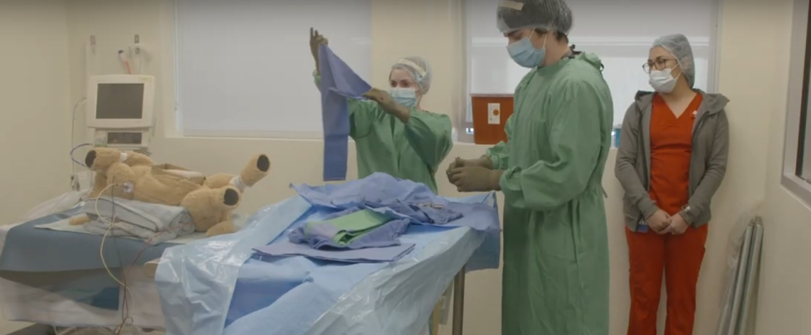Three veterinary students participate in a surgery and anesthesia simulation.