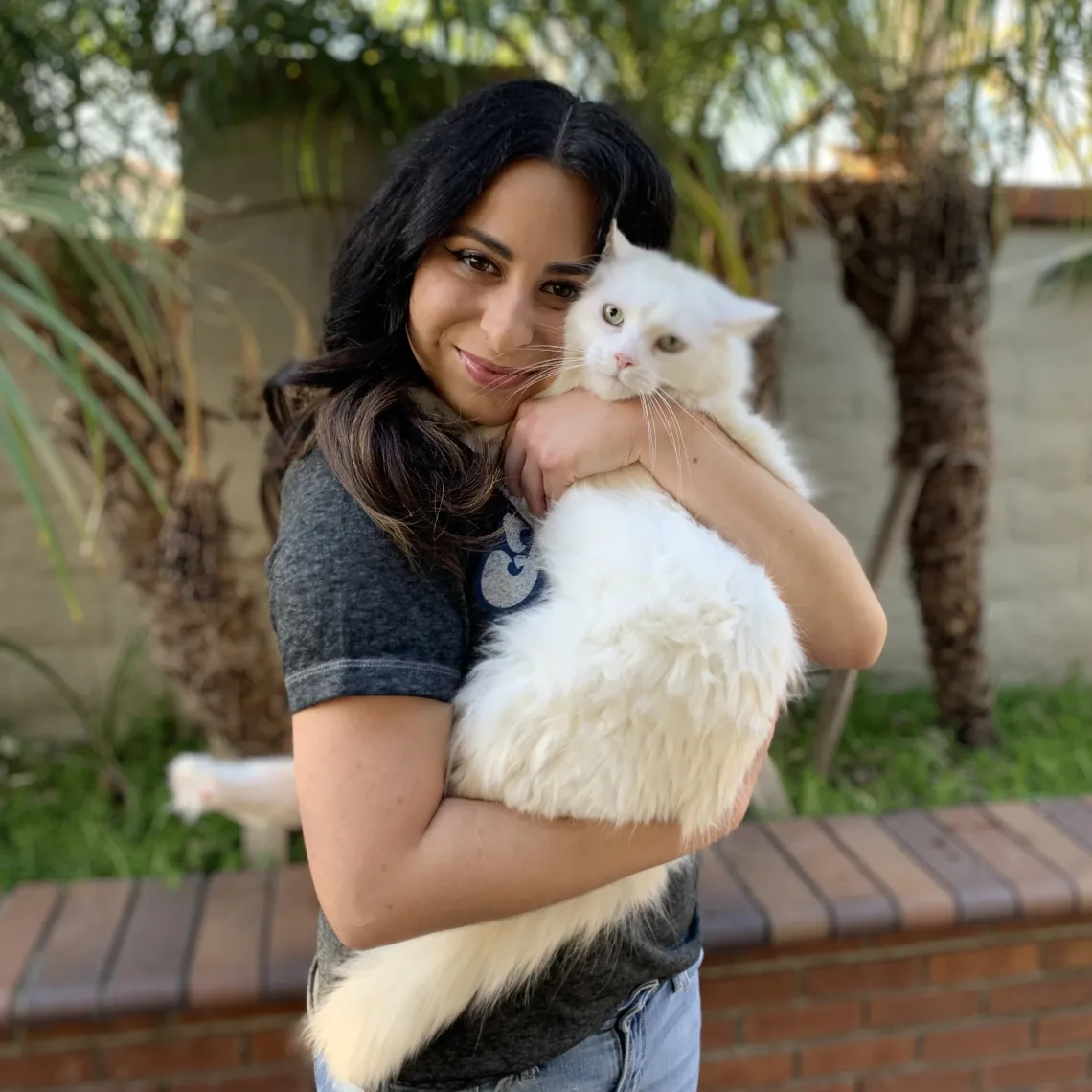 Veterinary student Cristina Guijon holds a white cat.