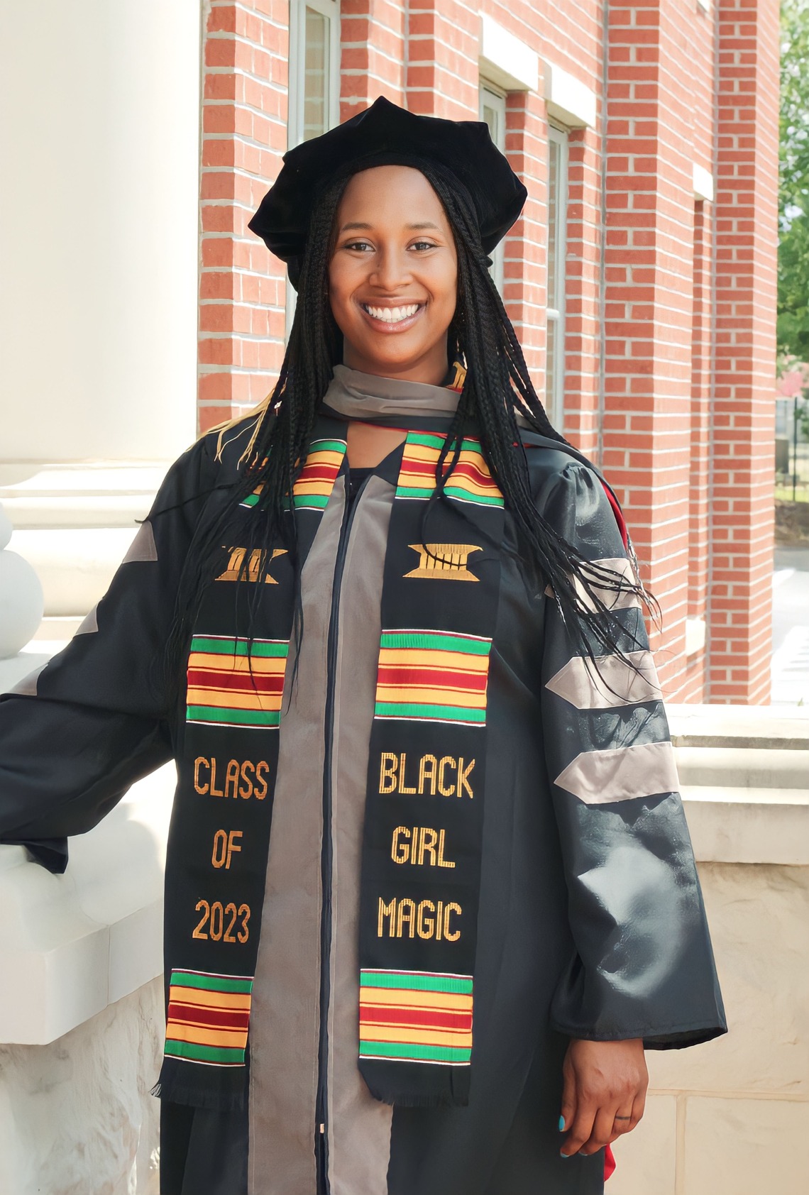 Jasmine Worthy wears graduation regalia and a graduation stole that reads "Class of 2023" and "Black Girl Magic."