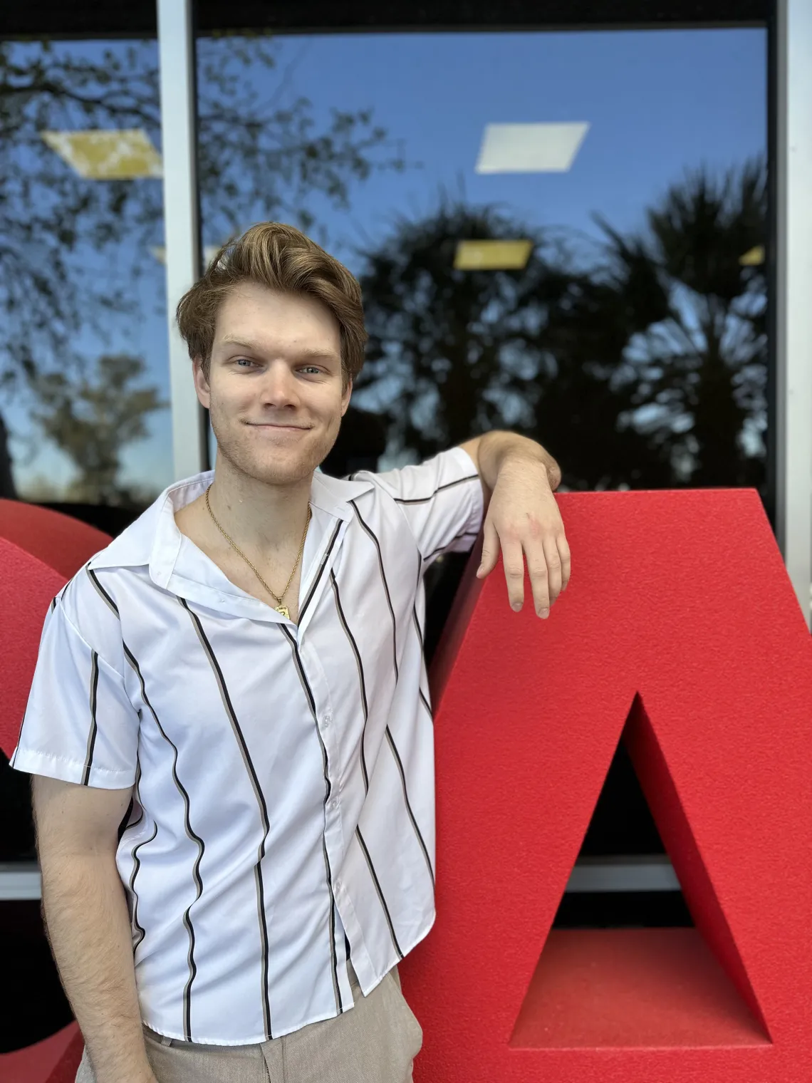 Rauland La Russa poses in front of large red letters that read "VetCats."