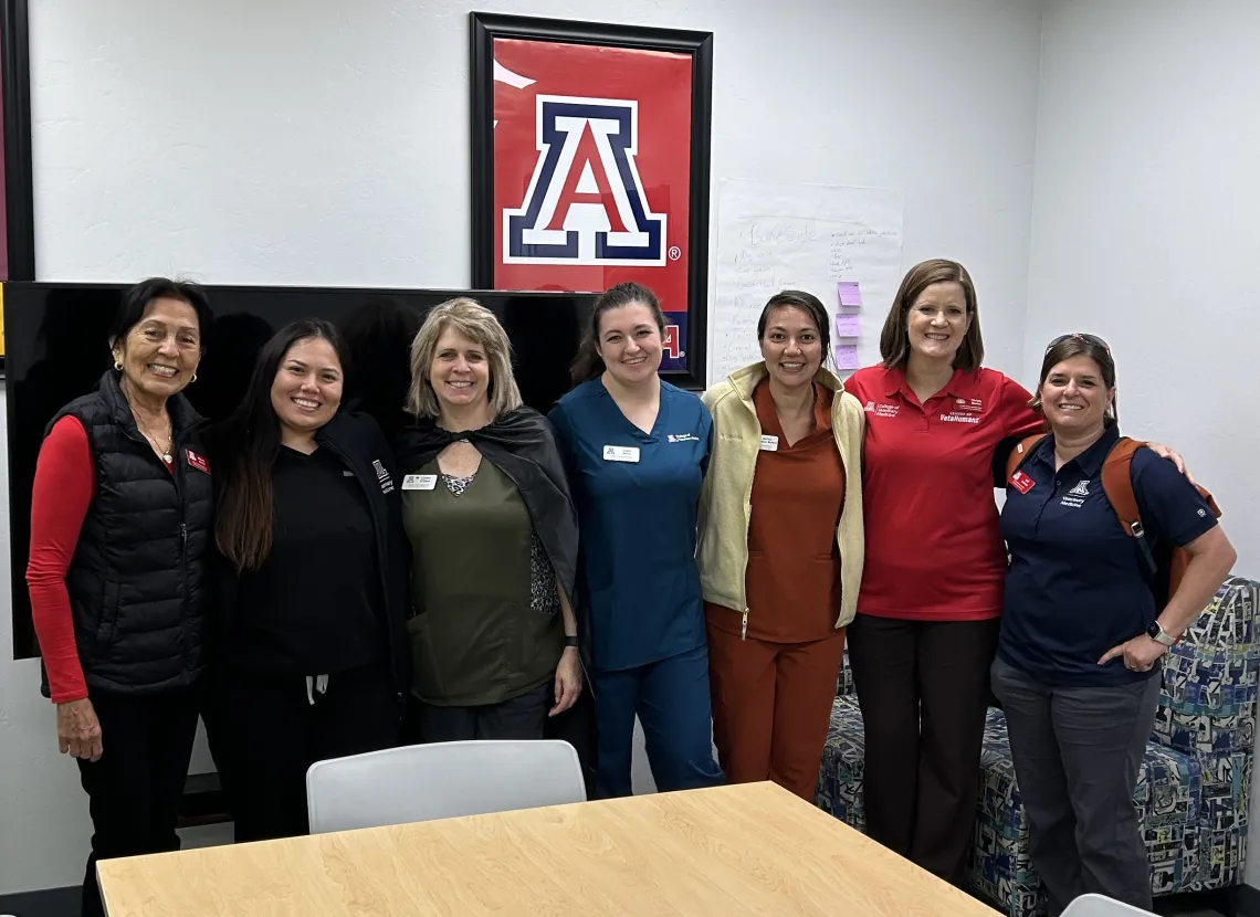 A group of seven College of Veterinary Medicine faculty and staff members pose together and smile.