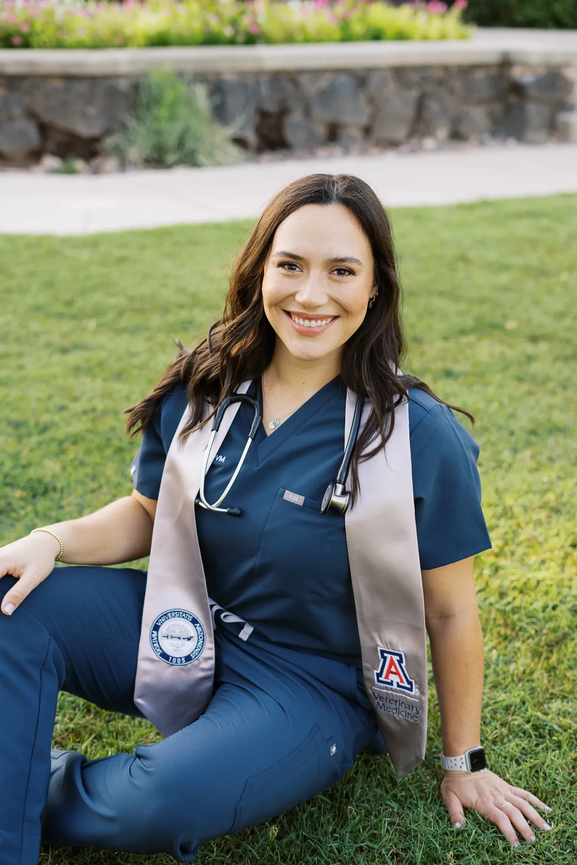 Alyssa Rankin smiling and sitting on the grass.