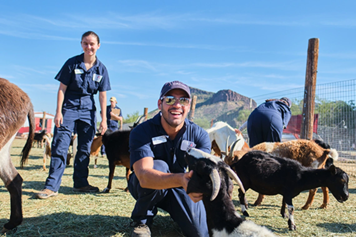 Student smiling with goat