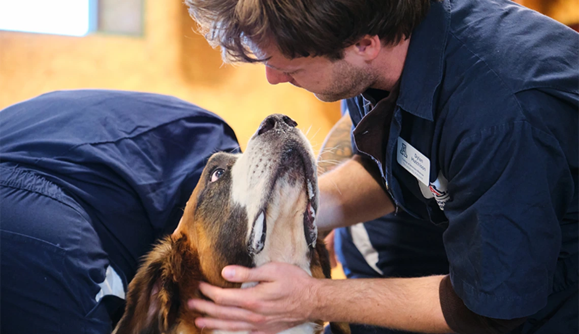 Student looking down at dog