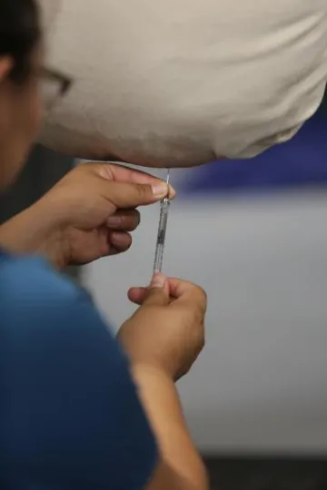 A student simulates an abdominocentesis procedure. 