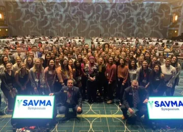 A crowd smiles for the camera at SAVMA Symposium.