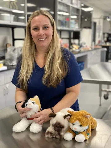 Lisa Hallam demonstrates examining a cat with thyroid issues.