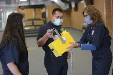 Dr. Gayle Leith shows a model radiology box to two veterinary students.