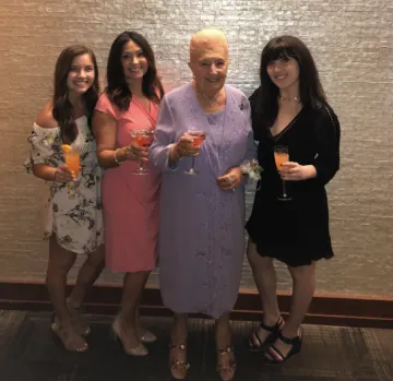 Four smiling women pose together.