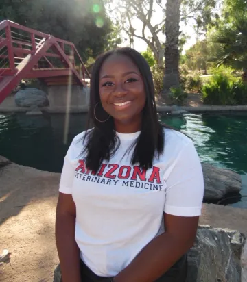 Ari Adams wears an Arizona Veterinary Medicine t-shirt and sits outside.