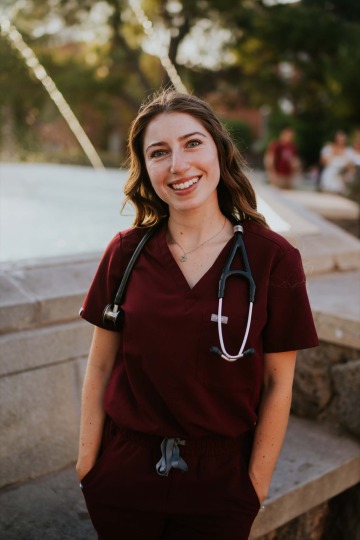 Adina Bronshtein wears scrubs and a stethoscope and smiles.