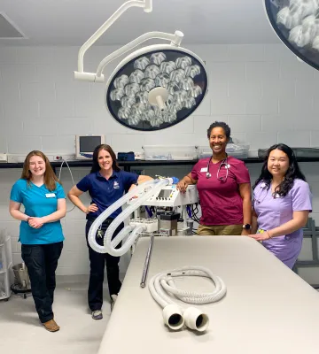 Students and Dr. Alexis Roth pose in an operating room at Reid Park Zoo.