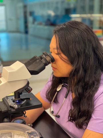 Student Teng Gater uses a microscope to analyze a blood sample.