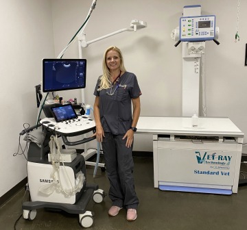 Dr. Lindsay Juhl stands next to veterinary equipment.