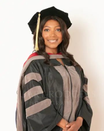 Deianira Smith wears graduation regalia and smiles.