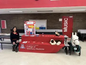 Dr. Alberta Arviso sits at a table at a local school. With her is a display entitled "Want to Be a Vet?"