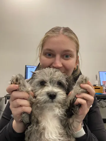 Brooke with a puppy looking happy.