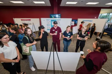 Students present their research posters at the inaugural research day.