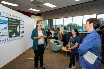 Sara Leighton presents her poster to Dean Julie Funk