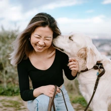 Girl being licked by her dog. 